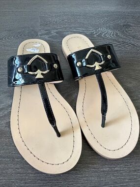 KATE SPADE NEW YORK Black Patent Thong Sandals with Silver Spade Accent